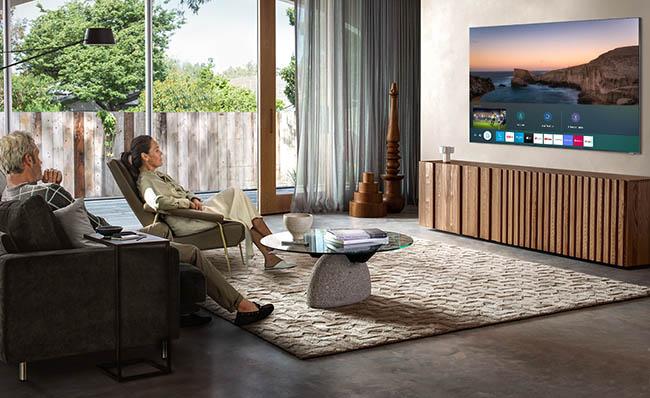 Una pareja de personas mayores ve la televisi&oacute;n en un televisor inteligente de Samsung
