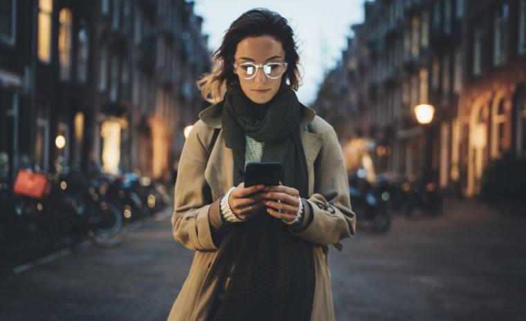 Una mujer utiliza su smartphone en una calle de noche