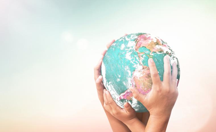 Varias manos sujetan un globo terr&aacute;queo