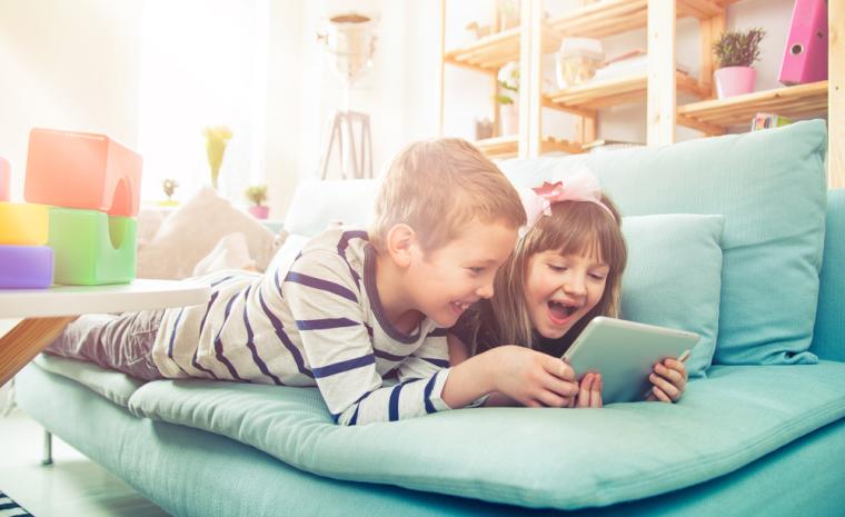 Dos ni&ntilde;os utilizan una tableta en su hogar