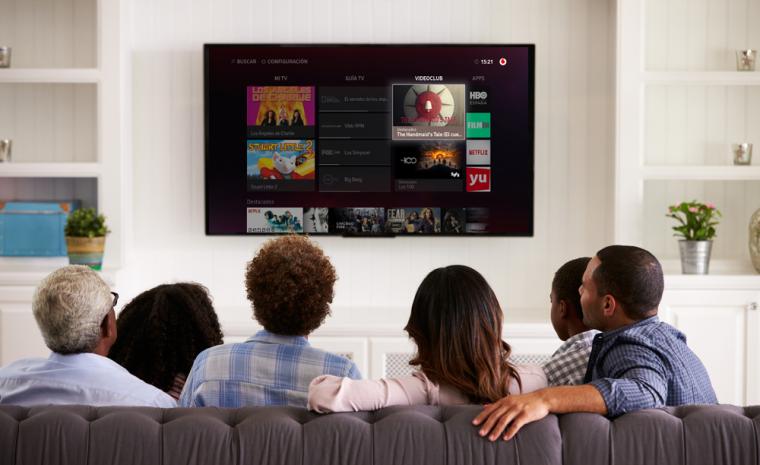 Varias personas sentadas frente a un televisor con el servicio de Vodafone de televisi&oacute;n