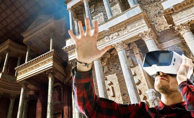 Fotomontaje de un joven visitando el Teatro Romano de M&eacute;rida con unas gafas de realidad virtual