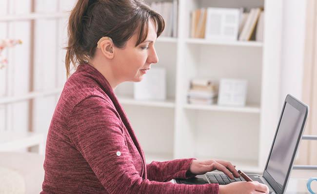Una mujer con discapacidad auditiva utiliza un ordenador port&aacute;til