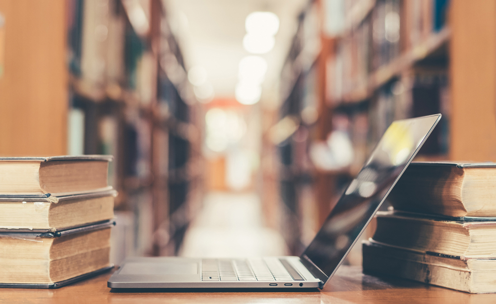 Un ordenador colocado entre libros viejos en una biblioteca