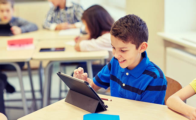 Un ni&ntilde;o utiliza una tableta en el aula