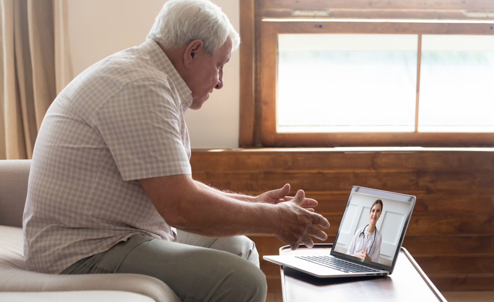 Un hombre mayor realiza una consulta con su médico a través de un ordenador