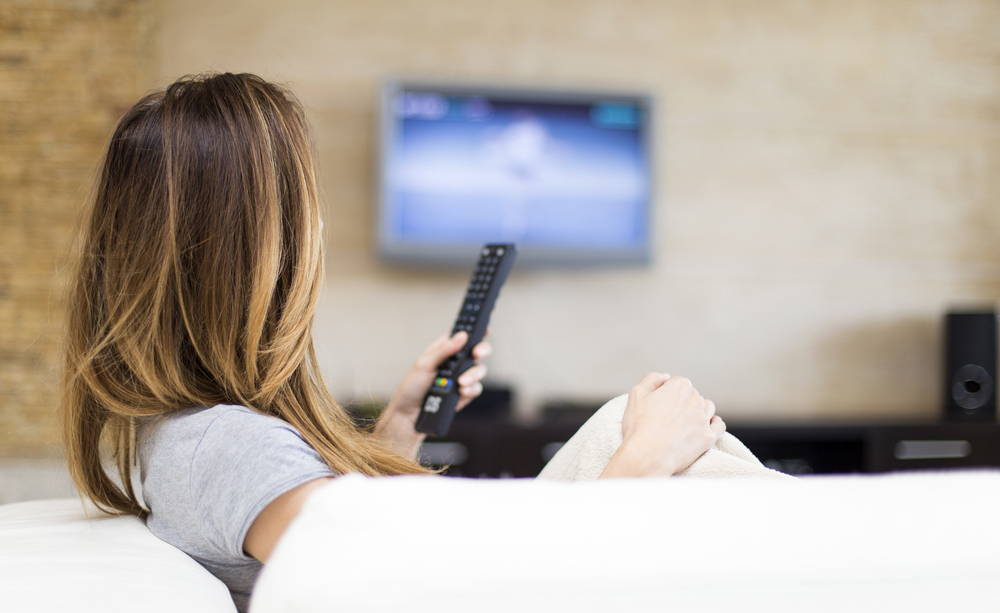 Imagen de una mujer sentada viendo la televisión