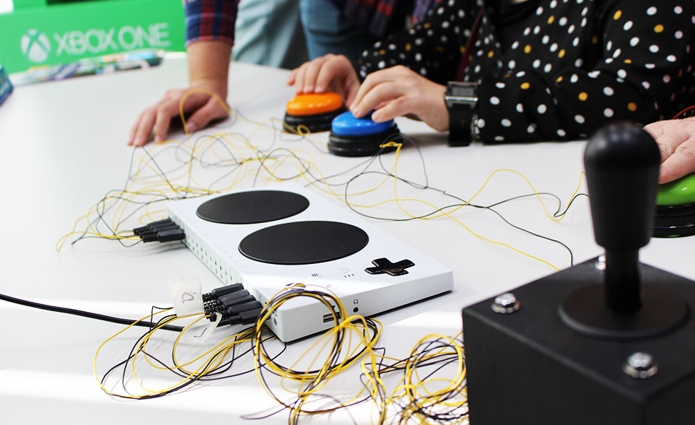 Varias personas utilizan el mando adaptado de Xbox mediante pulsadores